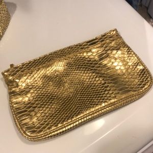 Gold tone faux snake skin Guess clutch. And gold belt.